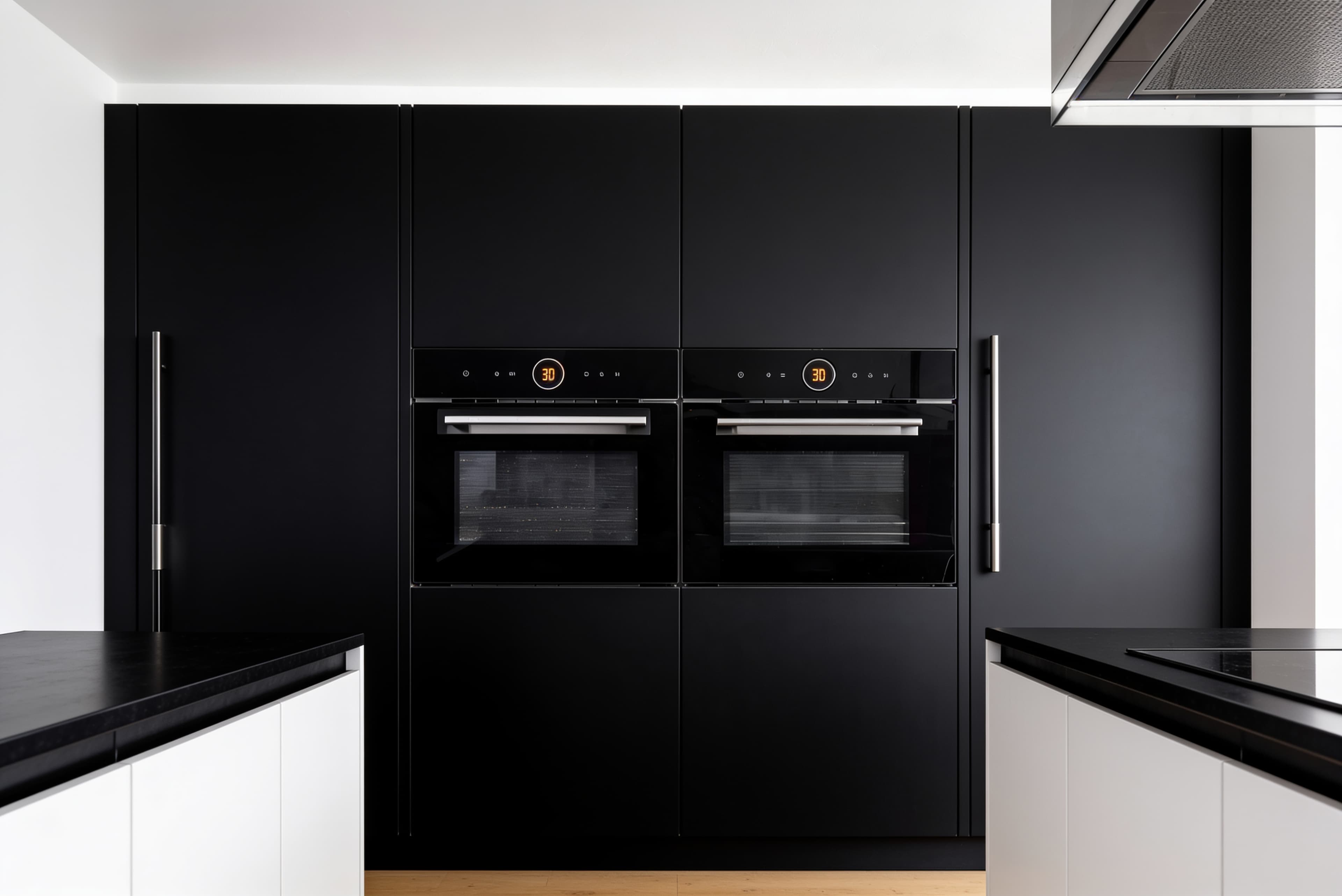 A matching pair of Carysil CX built-in ovens flush-fitted into a black kitchen wall