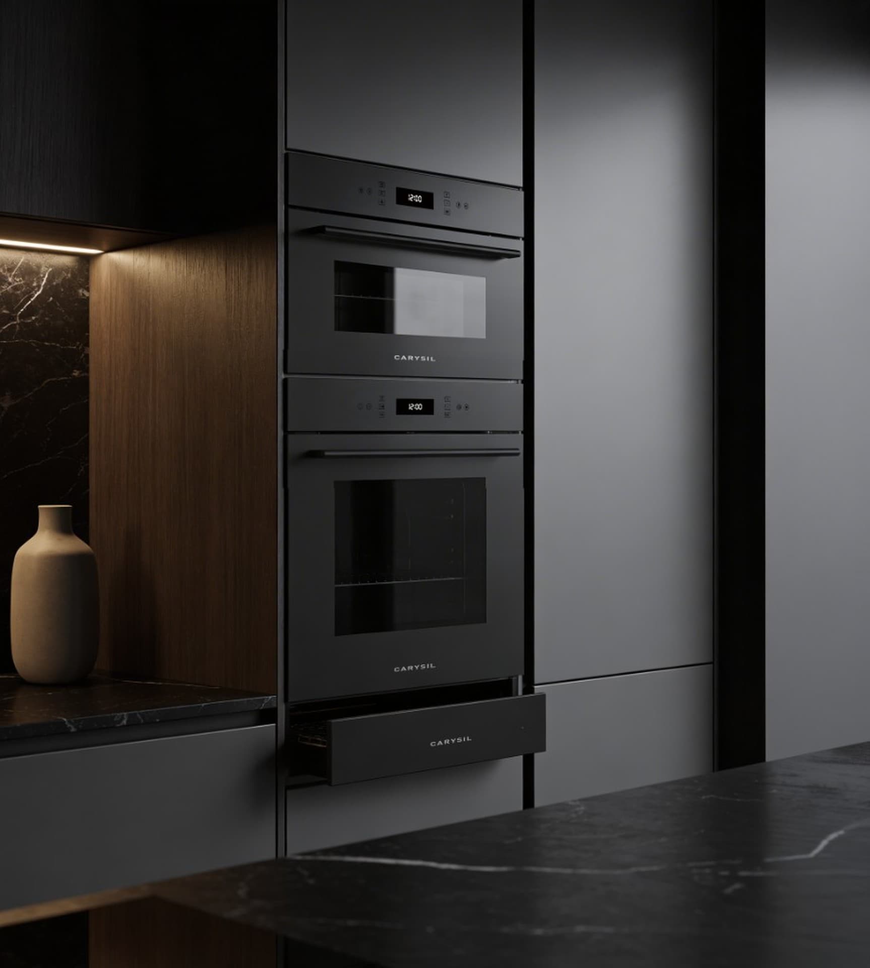 Carysil Eclipse oven, combi and warming drawer stacked in a dark marble kitchen