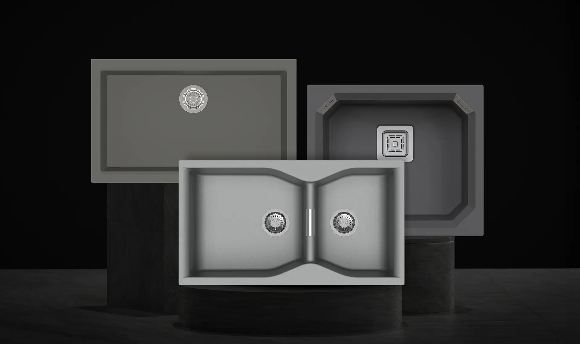 Three Carysil quartz kitchen sinks - single bowl, double bowl and octagonal - displayed on dark stone